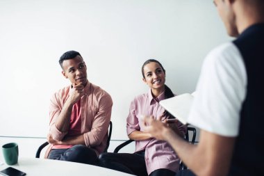 Koçluk sırasında beyin fırtınası toplantısından keyif alan erkek ve kadın, başlangıç ve gülümseme detaylarını tartışıyor.