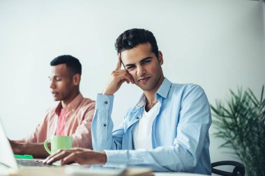 İspanyol erkek metin yazarlarının portresi modern dizüstü bilgisayarda uygulama için makale hazırlamak için zaman harcıyor, veritabanı bilgileriyle online çalışan çok kültürlü programcılar