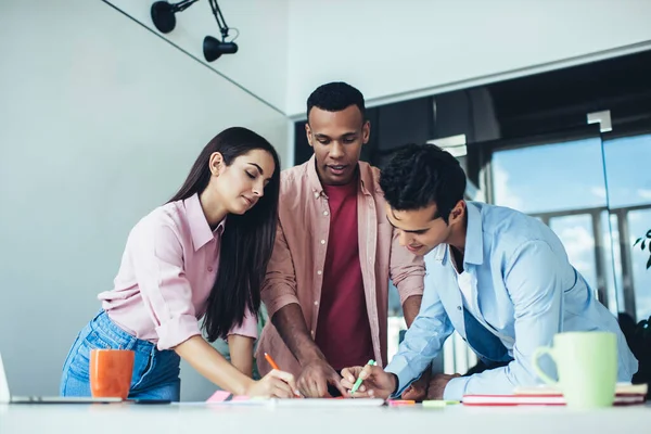 Group of clever male and female employees collaborating togetherness on project writing notes during brainstorming togetherness, intelligent man and woman searching solutions while briefing