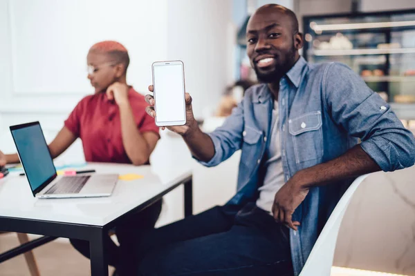 Schöner Afroamerikanischer Typ Lässigem Outfit Lächelt Und Demonstriert Modernes Smartphone — Stockfoto