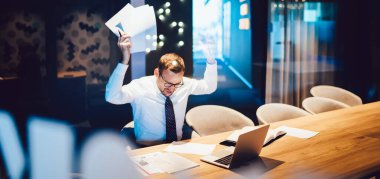 İşle ilgili sorunlar büyük borçlar ve iflas kavramı, şirketin beyaz erkek muhasebecisi kızgın hissederken masa başında oturan raporlardan elde edilen bilgileri kontrol etmeyi dene.