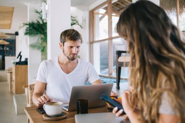 Kız arkadaşı cep telefonunda kablosuz telefon kullanırken, internet üzerinden internet bağlantısı kuran arkadaşlarıyla çevrimiçi iletişim kuran başarılı erkek mesafe çalışanlarının arka görüntüsü