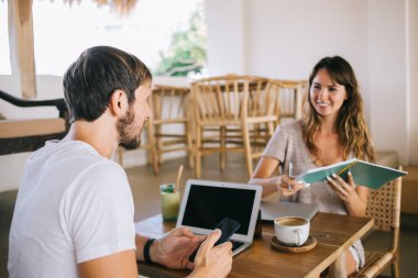 Metnin reklamını yapmak için alanı laptop ekranına kopyalayın, iki blogcu yeni yaratıcı fikirler üzerinde işbirliği yapıyor ve kafeterya masasında teknolojiyle oturan yeni sosyal web sitesi hakkında konuşuyorlar