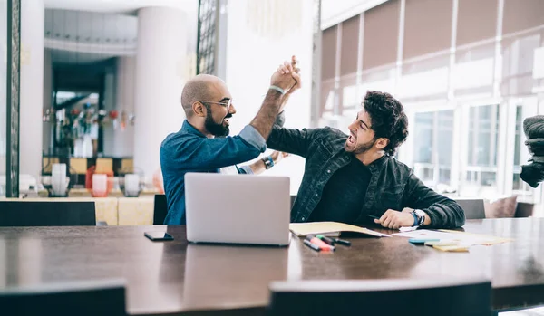 Vrolijke Casual Etnische Mannen Zitten Aan Tafel Met Papieren Laptop — Stockfoto