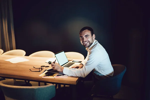Cheerful Caucasian proud ceo formally dressed feeling excited at office interior satisfied with finished startup project, happy businessman smiling at camera during working process in big enterprise