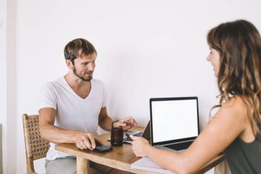 İnternet fırsatlarını tartışırken beyin fırtınası sırasında reklam metni için boş ekran alanı olan dizüstü bilgisayarlı bir çift serbest çalışan, iş birliği yapan pozitif uzaktan kumandalı programcılar