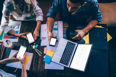 Yukarıdan gelen kadın ve erkek, kafede içki içerken beyaz ekranlı cep telefonları kullanıyor ve yeni bir proje üzerinde çalışıyorlar.