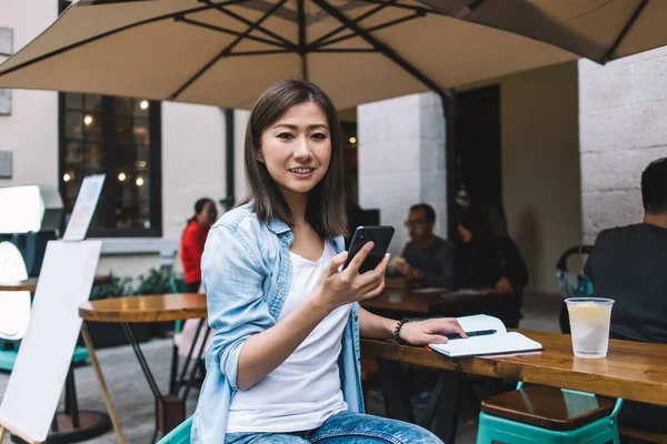 Portret Pozytywnej Chińskiej Hipsterki 20S Nowoczesnym Smartfonem Komórkowym Ręku Uśmiecha — Zdjęcie stockowe