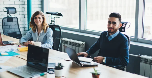 Ofis masasının yanında birlikte çalışan ve yönetim projesinden, girişimcilikten ve takım çalışmasından ayrılırken kameraya bakan mutlu erkek ve kadın finans uzmanlarının portresi