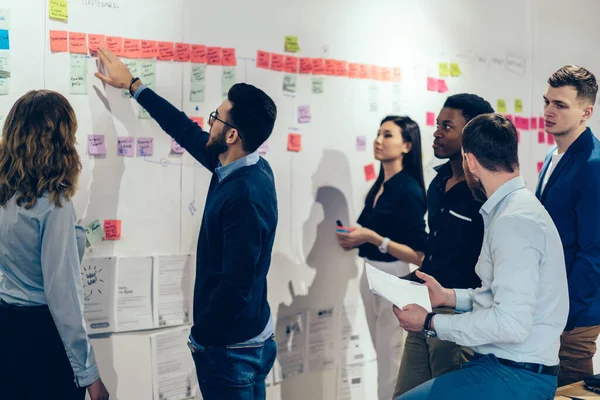 Genç çeşitlilik tayfası birlikte ticaret deneyimi hakkında tartışan ve hayal gücüyle strateji oluşturan erkek ve kadın iş adamları şirket toplantısını planlıyorlar.