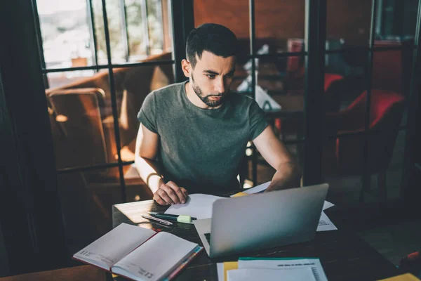 Jovem Homem Casual Focado Sentado Mesa Com Bloco Notas Digitando — Fotografia de Stock