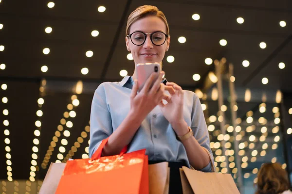 Fröhliche Shopaholic Mit Einkaufstüten Und Blick Auf Smartphone Bildschirm Beim — Stockfoto