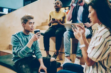 Ofiste kahve molası veren çok ırklı meslektaşların görüntüsü, üniversite kampüsünde birbirleriyle konuşan erkek ve kadın öğrencilerin modern cihazlar ve kablosuz internet bağlantıları.
