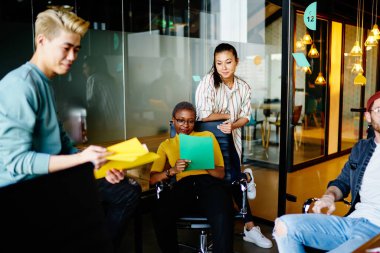 Modern ofis içinde yeni bir başlangıç projesi için birbirleriyle işbirliği yapan bir grup çok kültürlü hippi kız. Ofiste oturup kalkınma planı hakkında tartışan gençler grubu.