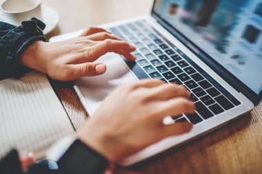 Modern dizüstü bilgisayarın klavyesinde ders metni yazmak için yazı yazan kadınların kırpılmış görünümü. Web sitelerinde arama bilgileri ve netbook aygıtında kablosuz internet kullanarak uygulama kurulumu