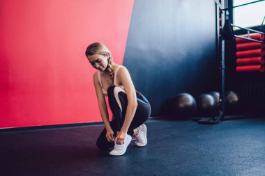 Spor salonunda kardiyo çalışmasından önce ayakkabı bağlayan kadın elleri, pilates stüdyosunda eğitime hazırlanan çekici kadın, aktif ve sağlıklı spor yaşam tarzı konsepti.