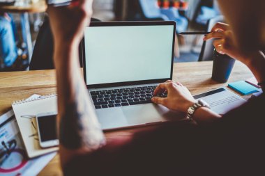 İnternet içeriğiniz için bilgisayarınızda bulunan dizüstü bilgisayarlı genç bir adamın arka plan görüntüsü. Hipster IT geliştiricisi kablosuz 4G bağlantısı kullanarak bilgisayarda serbest çalışma yapıyor.