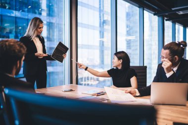 Resmi olarak çalışan zeki erkek ve kadın iş arkadaşları, modern teknoloji ile birlikte masaüstünde oturan ve veri bilgilerini analiz eden şirketler için finansal rapor üzerinde birlikte çalışıyorlar.