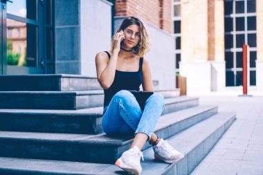 Üniversite programı hakkında danışmanlık için uluslararası telefon görüşmesi yapan çekici kız öğrencinin portresi ve klasöre not düşmesi, genç bir kadının şehir ortamında kameraya bakması