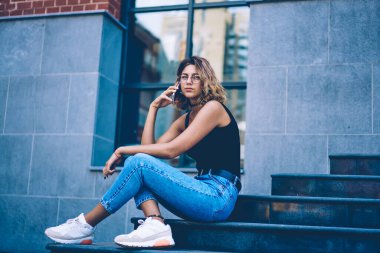 Genç ve güzel bir kızın portresi kameraya bakarken müşteri hizmetlerini arıyor. Gezici bağlantıların detaylarını tartışıyorlar. Genç çekici hippi kız telefon konuşması yapıyor.