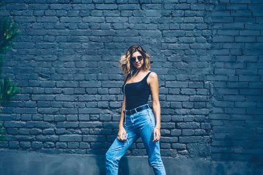 Kendine güvenen hippi kızın yarım boy portresi kot giyerek en sevdiği müziği elektronik kulaklıkla dinliyor, kulaklıklı genç bir kadın boş zamanlarında ses kayıtlarının keyfini çıkarıyor.