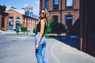 Çekici hippi kızın yarım boy portresi şehir merkezinde yürüyor ve boş zamanlarında uluslararası akıllı telefon konuşmaları yapıyor, genç trend bir kadın kiralık araba için taksi servisini arıyor.