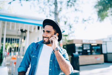 Şık giyinmiş İspanyol hippi şehir ortamında pozitif hücre sohbetinin keyfini çıkarıyor. Neşeli adam telefon numarasını soruyor. Cevap alınca mutlu olan kim?