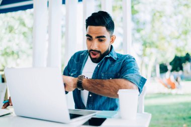 Türk erkek serbest programcı, dizüstü bilgisayarla yeni başlatılan proje için web sitesi oluşturduğu için şaşırmış durumda.