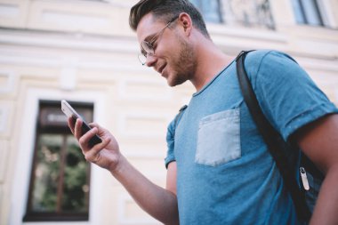 Milenyum hipster 'ı, akıllı telefondaki mesajları ve postaları kontrol ediyor. Boş zamanlarında online dağıtım sayısını araştırıyor. Yakışıklı turist 20' li yaşlarda cep telefonunu kontrol ediyor.