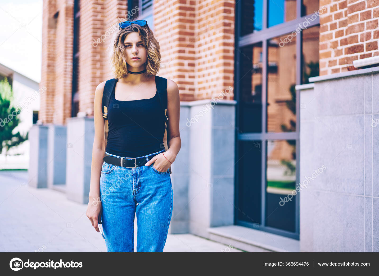 Mulher moderna. comprimento total de uma jovem atraente em roupa casual  elegante olhando para longe e sorrindo em pé contra um fundo cinza