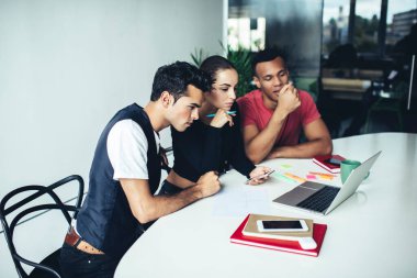 Gençlerden oluşan bir grup, modern dizüstü bilgisayarda 4G kablosuz internet sitesine bağlı olarak üniversite web sitesine yoğunlaştı, uygulamayla çok kültürlü erkek ve kadın videoları izliyor.