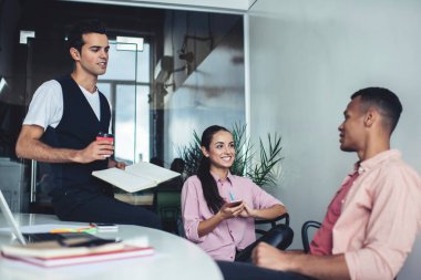 Başarılı çok kültürlü meslektaşlar, proje detayları hakkında brifing vermek için ofis içi içişlerinde zaman geçiriyorlar, pozitif erkek ve kadın girişimciler işbirliğinden keyif alıyorlar.