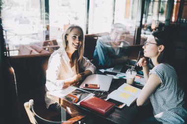 Kafe masasında kameraya gülümseyen erkek ve kadın iş arkadaşlarıyla dolu güzel, mutlu bir kadın penceresinden bakın.