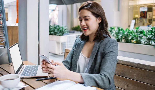 Unga Asiatiska Frilansare Meddelande Smartphone Medan Sitter Café Träbord Med — Stockfoto