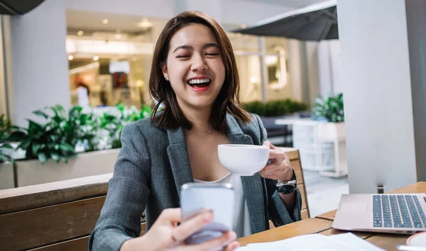Asiatisk Ung Affärskvinna Med Kaffekopp Skrattar Och Sitter Vid Trä — Stockfoto