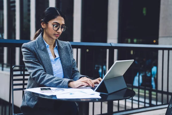 穿着雅致服装 戴着眼镜 头脑清醒的商务女士坐在桌旁 文件在户外 用平板电脑在纽约市的平台上发送电子邮件 — 图库照片