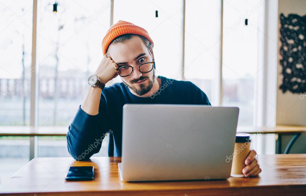 Shocked male freelancer amazed from received email with information about mistake in program code for laptop application feeling tired during remote deadline in coffee shop, concept of distance job