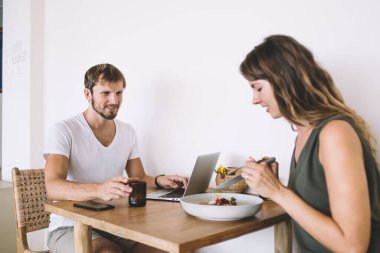Kafkasyalı çift öğle yemeği saatlerinde kafeteryada taze sebze salatası malzemelerini tartışırken dizüstü bilgisayar, arkadaşlık konsepti ve internet bağlantısı için iyi bir internet bağlantısı kuruyor.