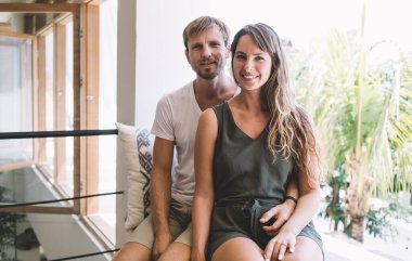 Endonezya bayramlarında pencere kenarında dinlenen ve halka açık yerlerde kameraya gülümseyen beyaz evli çiftin portresi, karı koca arasındaki ilişki ve aşk ilişkisi kavramı