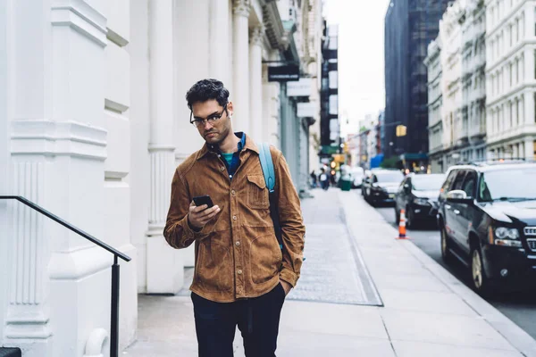 Confused Handsome Ethnic Casual Adult Man Glasses Backpack Browsing Smartphone — Stock Photo, Image