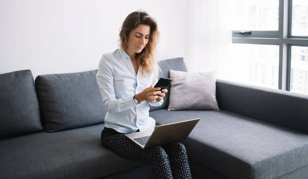 Jovem Mulher Camisa Calças Conversando Telefone Sentado Sofá Com Laptop — Fotografia de Stock