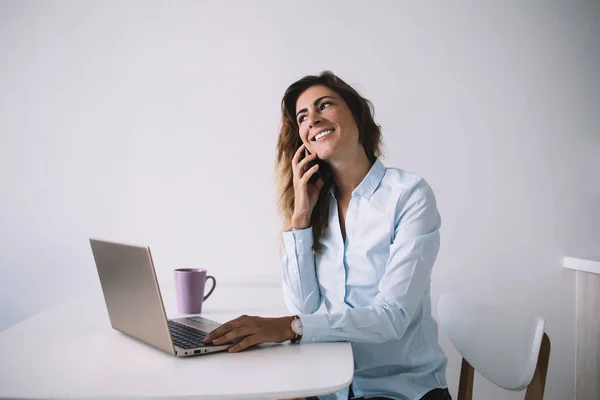 Resmi Tişörtlü Yetişkin Bir Kadın Telefonda Kahve Dizüstü Bilgisayarla Oturuyor — Stok fotoğraf
