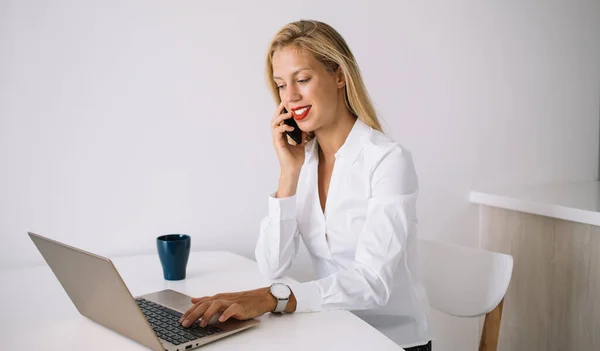 Vista Lateral Una Joven Empleada Sentada Escritorio Sonriendo Mientras Escribe — Foto de Stock