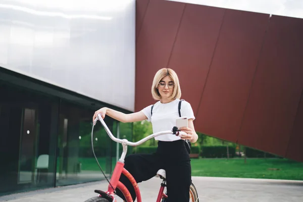 Atractiva Joven Gafas Mensajería Las Redes Sociales Sentada Bicicleta Roja — Foto de Stock