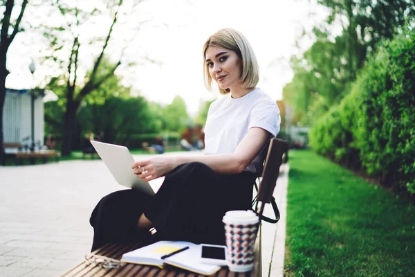 Freelancer Feminino Confiante Trabalhando Laptop Olhando Para Câmera Enquanto Sentado — Fotografia de Stock