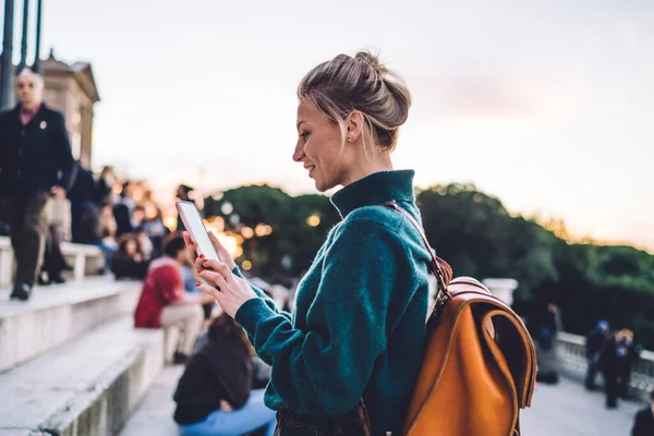 ヘアブンとブラウンバックパック付きの美しい女性観光客が街を歩き スマートフォンで地図を使用する方法を探しています — ストック写真