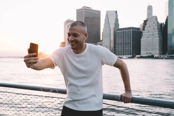 Kulaklıklı Akıllı Telefonuyla Gülümseyen Selfie Çeken Genç Yakışıklı Etnik Adam — Stok fotoğraf