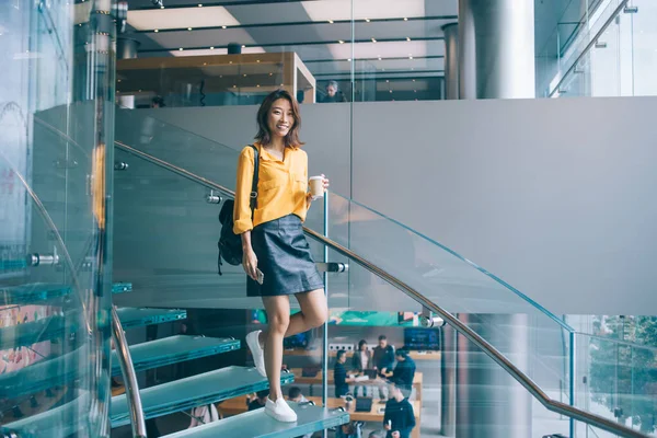 フルボディ若い正の美しい明るいアジアの女性で黄色のシャツ黒革のスカートとバックパック行く階段でコーヒーと携帯電話で香港 — ストック写真