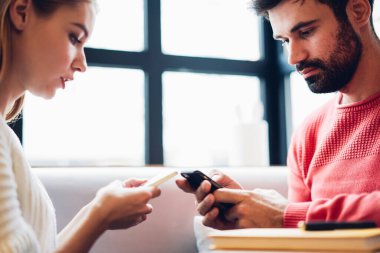 Çift cep telefonu kullanıyor. Medya görünümlü cihaz ekranı okuyor. Boş vakitlerini internet iletişiminde geçiriyorlar. Birbirlerini görmezden geliyorlar.
