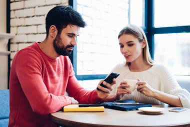 Millennial hipster çalışanları internet sitesinden gelen bilgileri modern cep telefonu aygıtı ile analiz ediyorlar, Kafkas nesli akıllı telefon cihazının 4G 'ye bağlı uygulaması için arama tebligatı